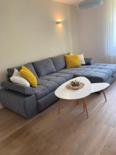 a living room with a blue couch and a white table at Ústí nad Labem, Apartmány pod hradem Střekovem in Ústí nad Labem