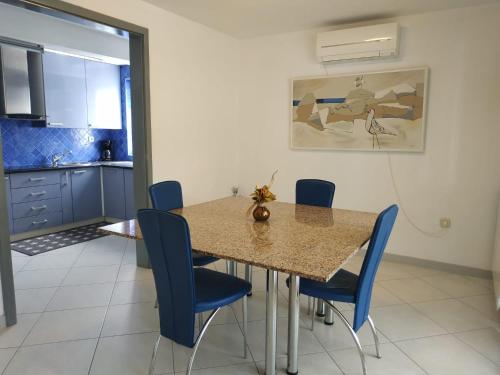 une salle à manger avec une table et des chaises bleues dans l'établissement Rezidence Palma 2, à Poreč