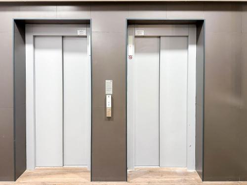 three elevator doors in a building at ACM Premium 3 camere Apartament elegant in Voluntari