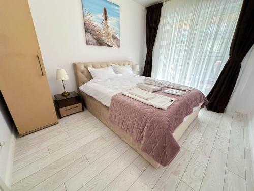 a bedroom with a bed and a large window at ACM Premium 3 camere Apartament elegant in Voluntari