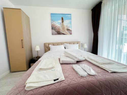 a bedroom with a large bed with a pink blanket at ACM Premium 3 camere Apartament elegant in Voluntari