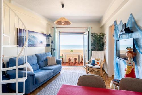 - un salon avec un canapé bleu et une vue sur l'océan dans l'établissement Pedrógão Sea View, à Pedrógão