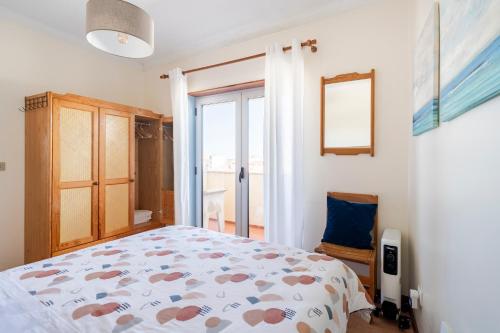 a bedroom with a bed and a sliding glass door at Pedrógão Sea View in Pedrógão