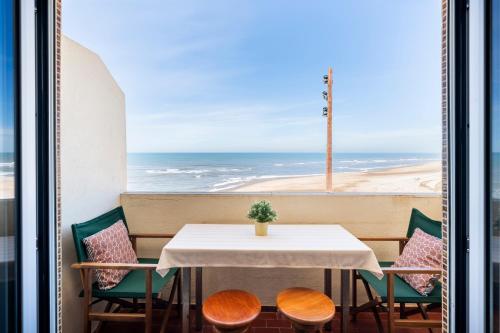 a table and chairs with a view of the ocean at Pedrógão Sea View in Pedrógão
