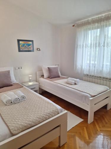 two beds in a room with white walls at Apartment Katarina in Vodnjan