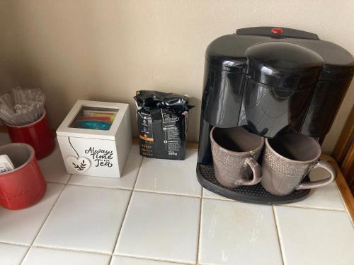 a coffee maker and two cups on a counter at Joli gîte 2 personnes en Alsace in Guémar