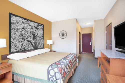 a hotel room with a bed and a flat screen tv at Super 8 by Wyndham Central City in Central City