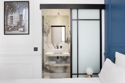 une salle de bain avec un lavabo et un miroir dans l'établissement Pick A Flat's Apartment in Louvre - Croix des Petits Champs, à Paris