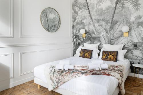 - une chambre avec un lit blanc et un papier peint tropical dans l'établissement Pick A Flat's Apartment in Louvre - Croix des Petits Champs, à Paris