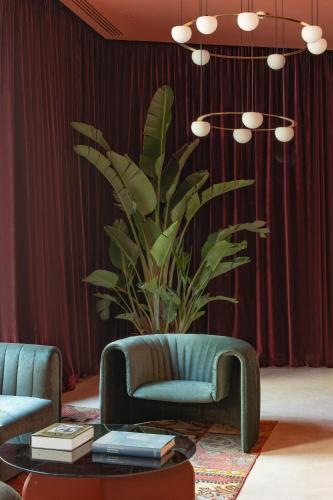 a living room with a couch and a table and a plant at Casa de las Artes, member of Meliá Collection in Madrid