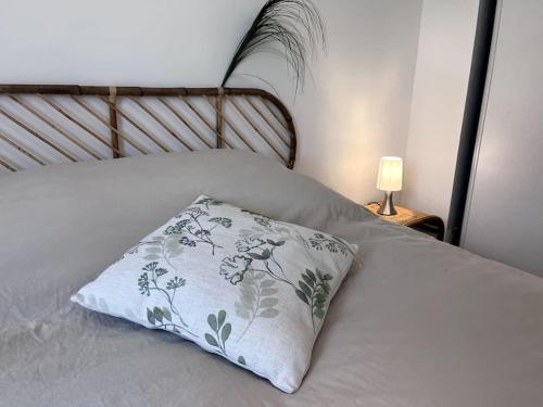 un lit blanc avec un oreiller dessus et une lampe dans l'établissement Evasion sur Vannes avec terrasse et jardinet, à Vannes