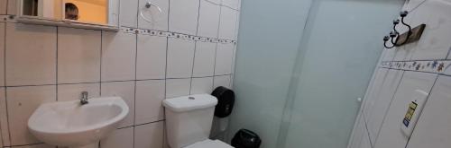 a white bathroom with a sink and a toilet at Pousada Mirante da Serra Fonte Sônia-Valinhos in Valinhos