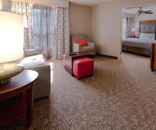 a living room with a couch and a red suitcase at Homewood Suites by Hilton Ft. Worth-Bedford in Bedford