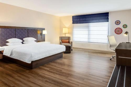 a hotel room with a large bed and a window at Hampton By Hilton San Jose Airport Costa Rica in Alajuela City