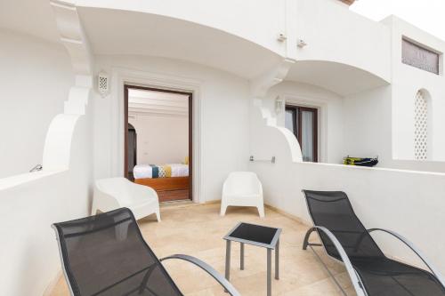 a room with two chairs and a table and a bed at Hotel Vecchia Marina in Àrbatax