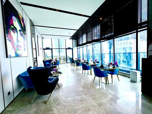 a restaurant with blue chairs and tables and windows at Star Residence Suite KLCC in Kuala Lumpur