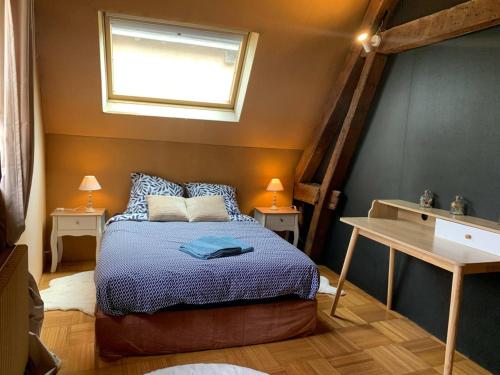 une chambre avec un lit avec une couette bleue et une fenêtre dans l'établissement Maison Saint Pierre, à Chartres