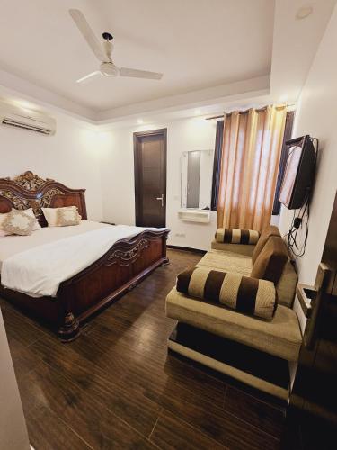 a bedroom with a bed and a tv and a chair at Hostmystay- 3Bhk Terrace! Gk1 M block in New Delhi