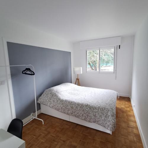 une chambre blanche avec un lit et une fenêtre dans l'établissement Chambre Ananas à saint Marceau, à Orléans