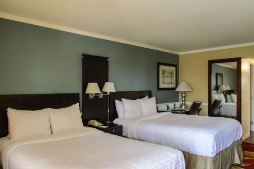 a hotel room with two beds and a mirror at Clarion Inn Near China Lake Naval Station in Ridgecrest