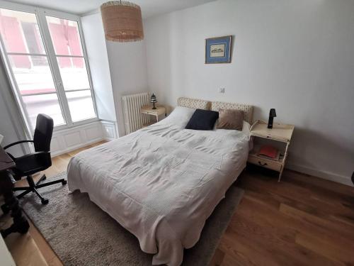 une chambre avec un grand lit et un bureau dans l'établissement Saint-Jean de Luz, centre historique, apt 4 pièces - 6 couchages, à Sainte-Barbe