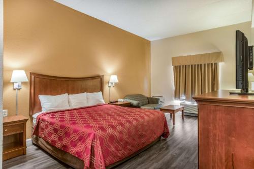a hotel room with a bed with a red bedspread at Econo Lodge Inn & Suites Marietta near Dobbins ARB in Marietta