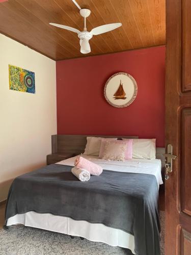 a bedroom with a bed with a red wall at Pousada do Tom in Lençóis