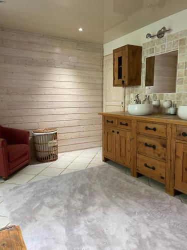 La salle de bains est pourvue d'un lavabo et d'une chaise rouge. dans l'établissement Maison La Glycine domaine viticole de 1 à 8 personnes, à Lauraguel