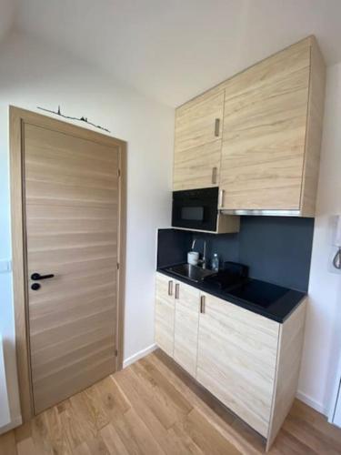 - une cuisine avec une porte en bois et un comptoir dans l'établissement Studio Trocadéro sur les toits, à Paris