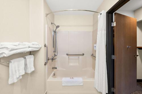 a bathroom with a tub and a shower with towels at Comfort Inn Van Wert in Van Wert