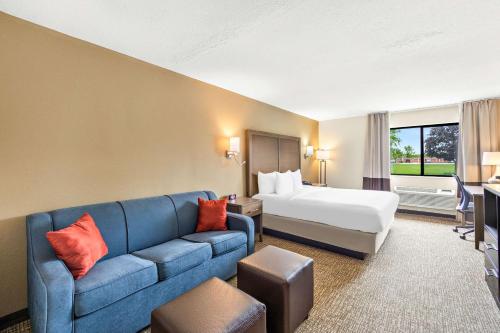 a hotel room with a bed and a blue couch at Comfort Inn Van Wert in Van Wert