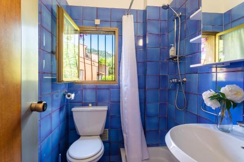 La salle de bains est pourvue de carrelage bleu, de toilettes et d'un lavabo. dans l'établissement VILLA LA PETITE RESERVE VI4416 By Riviera Holiday, à Èze