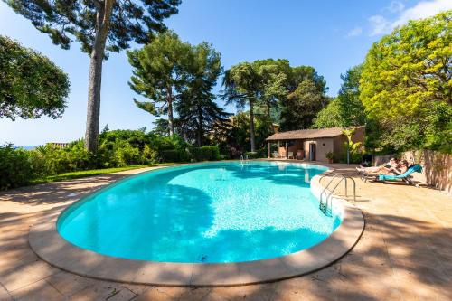 - une piscine avec 2 personnes assises dans des chaises à côté dans l'établissement VILLA LA PETITE RESERVE VI4416 By Riviera Holiday, à Èze