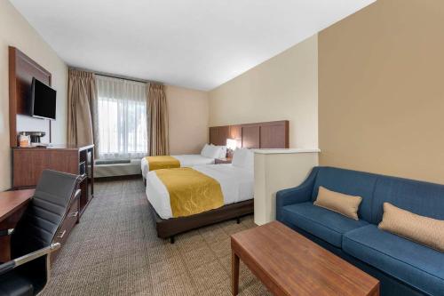 a hotel room with a bed and a couch at Comfort Suites in Tulare