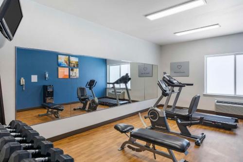 a gym with cardio equipment and chairs in a room at Comfort Suites in Tulare