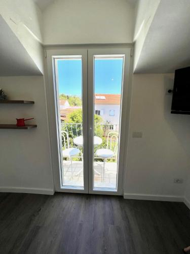 a room with a sliding glass door with a balcony at Vila Vera Seafront Apartments in Sumartin