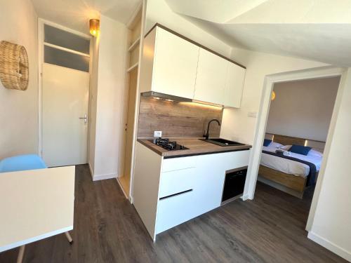a kitchen with white cabinets and a bed in a room at Vila Vera Seafront Apartments in Sumartin