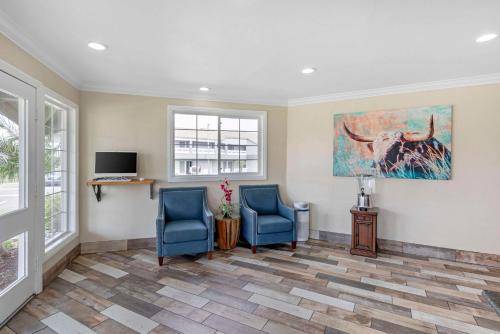 a living room with two blue chairs and a tv at Quality Inn Kettleman City near Hwy 41 in Kettleman City