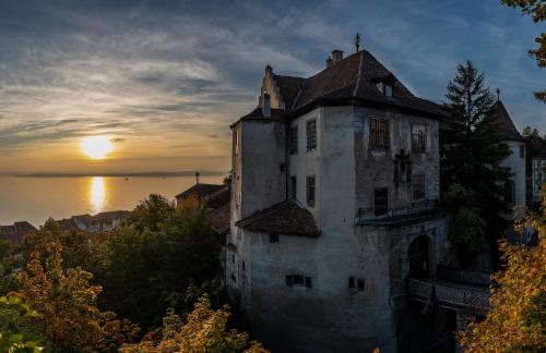 an old building with the sunset in the background at JUFA Hotel Meersburg am Bodensee in Meersburg