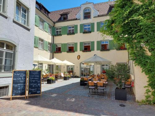 a building with tables and chairs in front of it at JUFA Hotel Meersburg am Bodensee in Meersburg