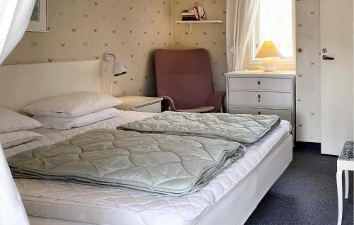 a bedroom with a bed and a chair in it at Amazing Apartment In Haverdal With Wifi in Haverdal