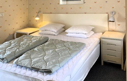a bedroom with a large bed and a night stand at Amazing Apartment In Haverdal With Wifi in Haverdal