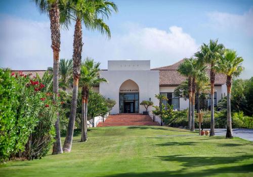 a house with palm trees in front of a yard at Impressive Playa Granada Golf in Motril