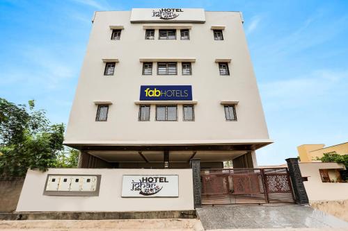 ein weißes Gebäude mit einem Schild darauf in der Unterkunft FabHotel Johar Inn in Raipur