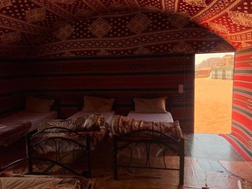 a room with three beds in a room with a ceiling at Wadi Rum Desert Adventures in Wadi Rum