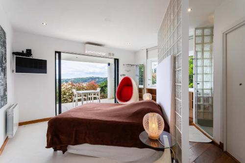 une chambre avec un lit et une chaise rouge dans l'établissement VILLA ADRIANA VI4411 By Riviera Holiday Homes, à Nice