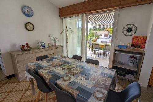 une salle à manger avec une table et des chaises et une cuisine dans l'établissement House near the beach of La Tranche-sur-Mer, à La Tranche-sur-Mer