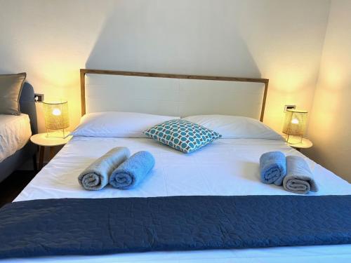 a bed with blue towels and pillows on it at Vila Vera Seafront Apartments in Sumartin