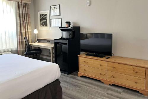 a hotel room with a bed and a flat screen tv at Country Inn & Suites by Radisson, Tucson Airport, AZ in Tucson