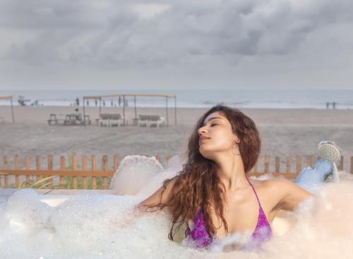 a woman sitting in a bath tub on the beach at Buena Vida Beach Resort in Morjim